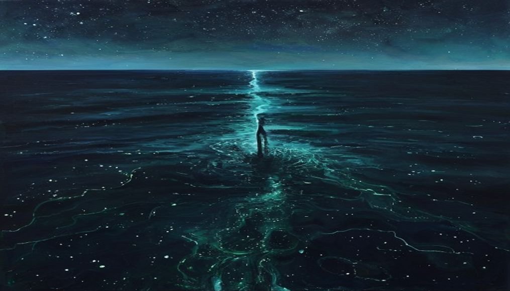 Figur am dunklen Meer bei Nacht — phosphoreszierendes Wasser